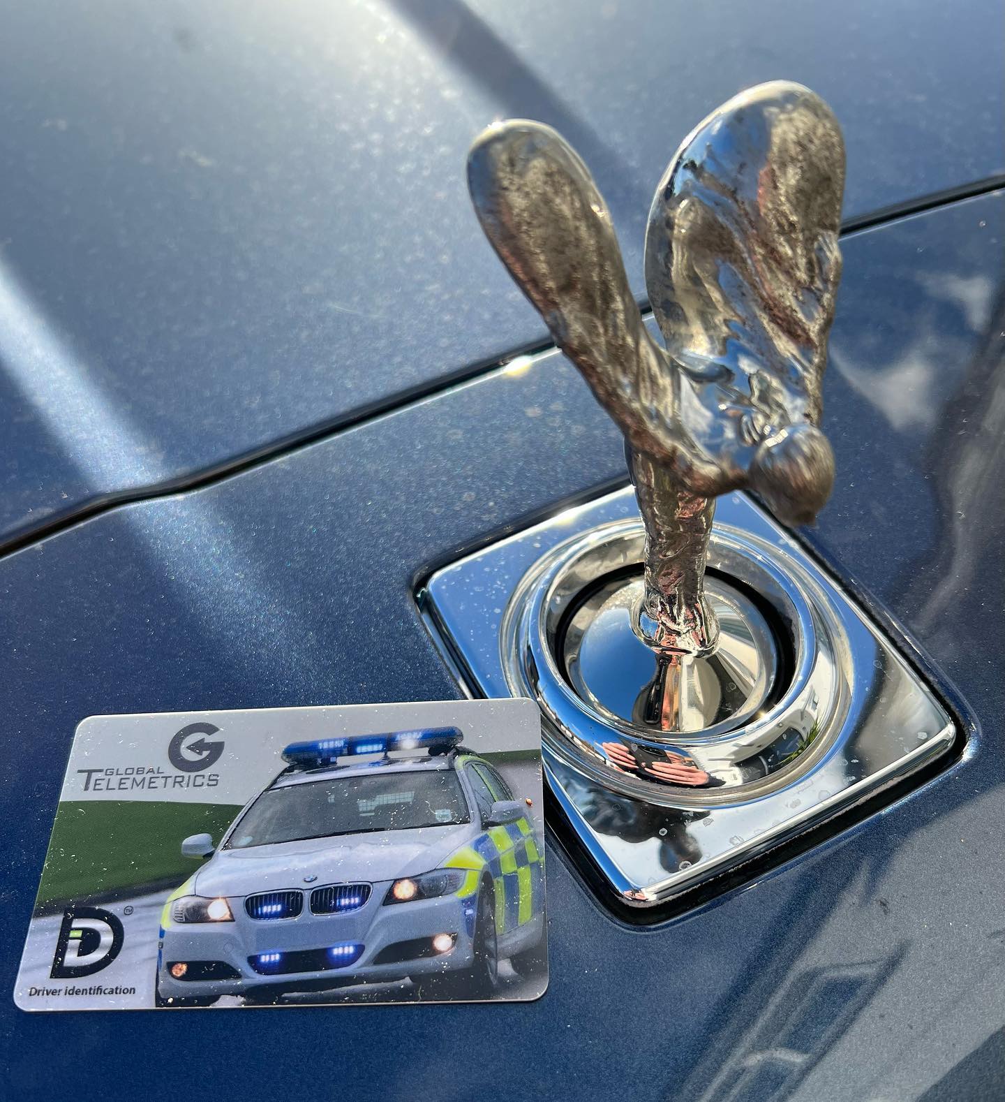 Rolls Royce Tracker Photo of spirit of ectasy on the front of a rolls royce next to a tracker recognition card